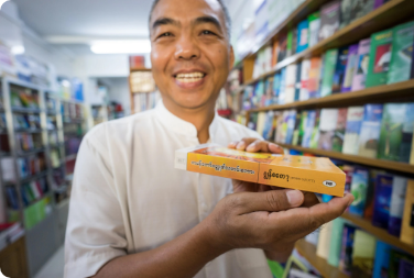 A man smiling with a book in his language